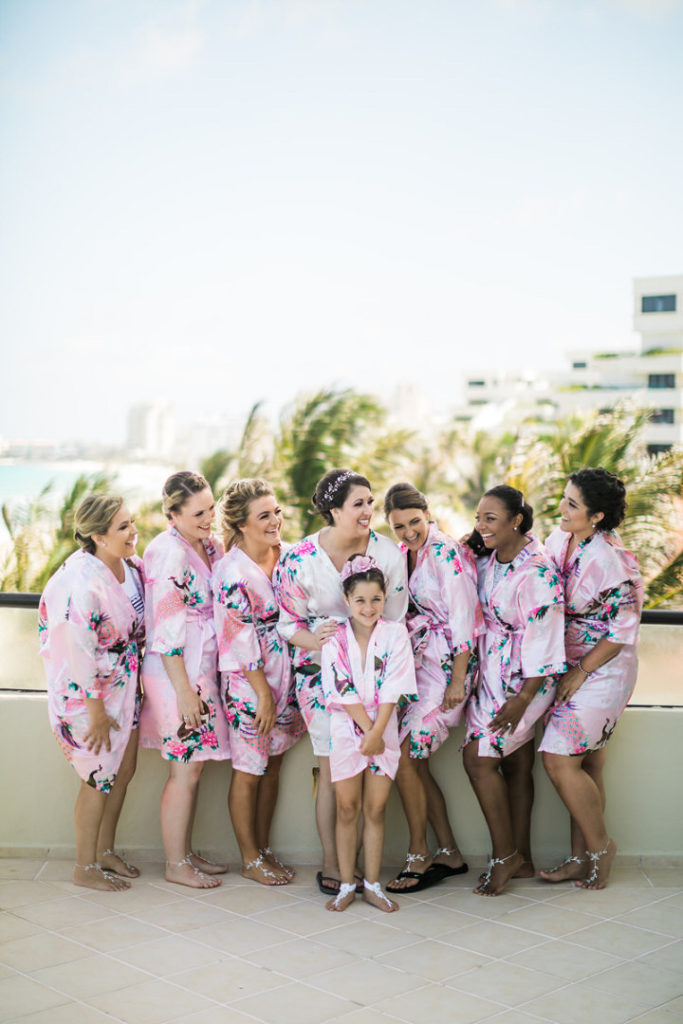 Bride and bridesmaids in matching robes outside on Crown Paradise Club balcony