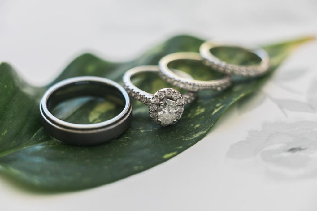 Macro photo of wedding rings on a green leaf