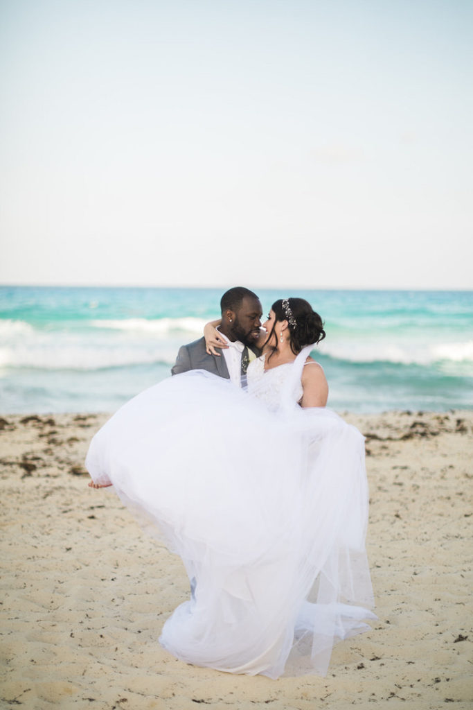Groom holds bride on the beach of their Crown Paradise Club Wedding