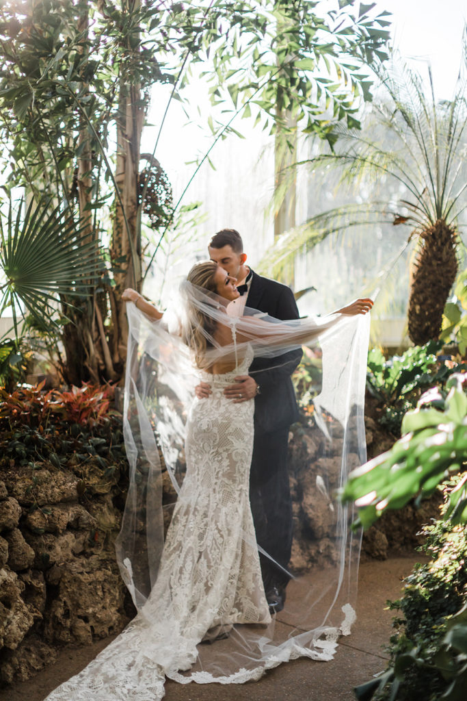 Bride and groom share take wedding photos inside Phipps Conservatory