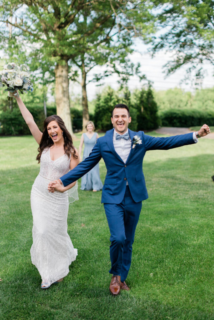Bride and groom cheer as they exit their summer Edgewood Club wedding ceremony