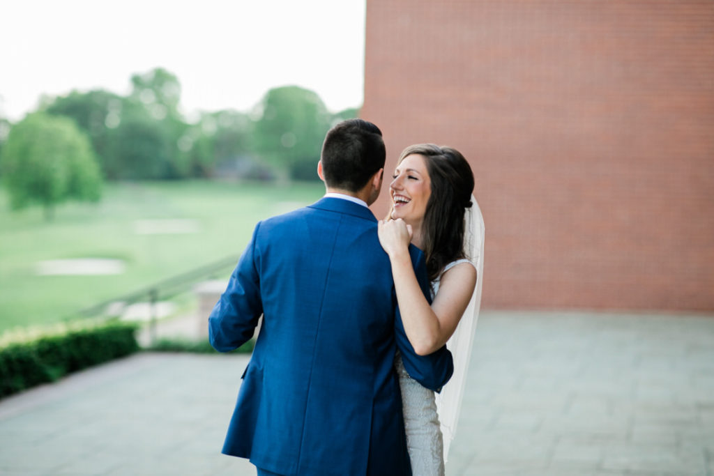 Bride and groom share first dance and laugh on the veranda at their summer Edgewood Club wedding