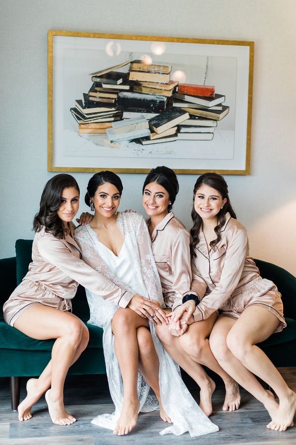Bride poses with her three sisters in their silk pajama sets