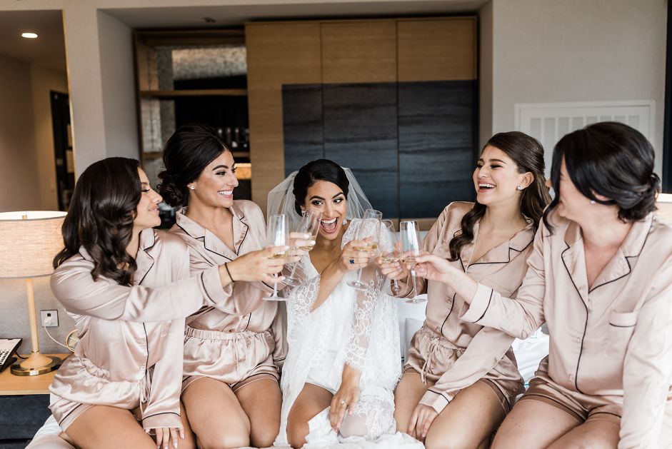 Bridesmaids toast with champagne in silk pajama outfits
