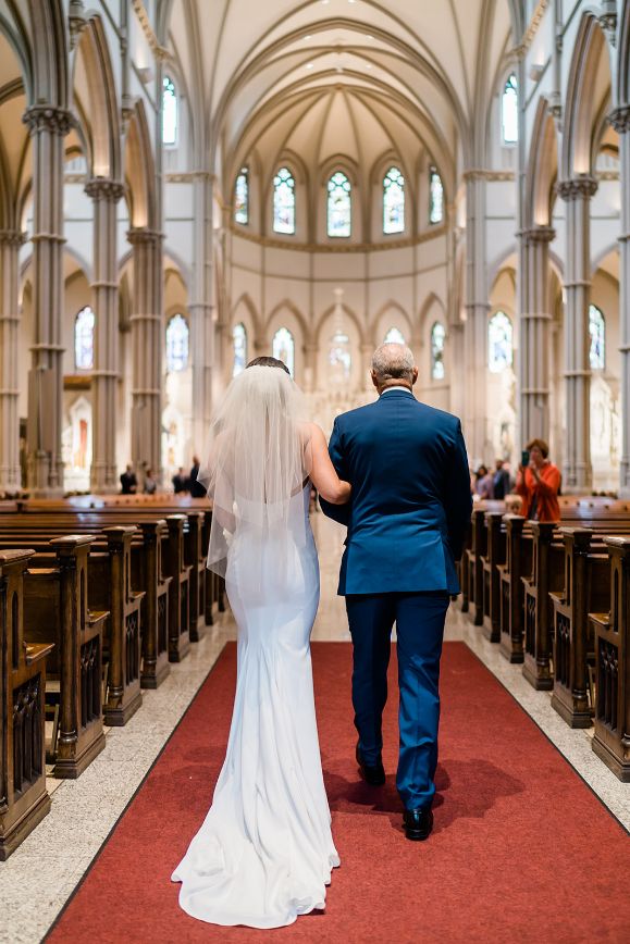 Bride and her father walk down the aisle of St. Paul's cathedral in Oakland