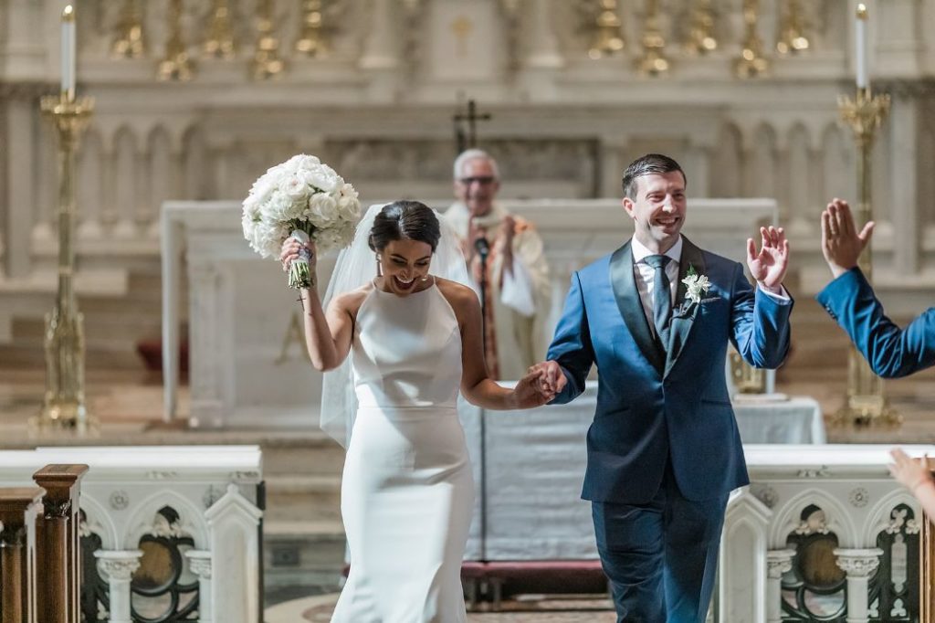 Bride and groom celebrate as they descend down the aisle at St. Paul's cathedral