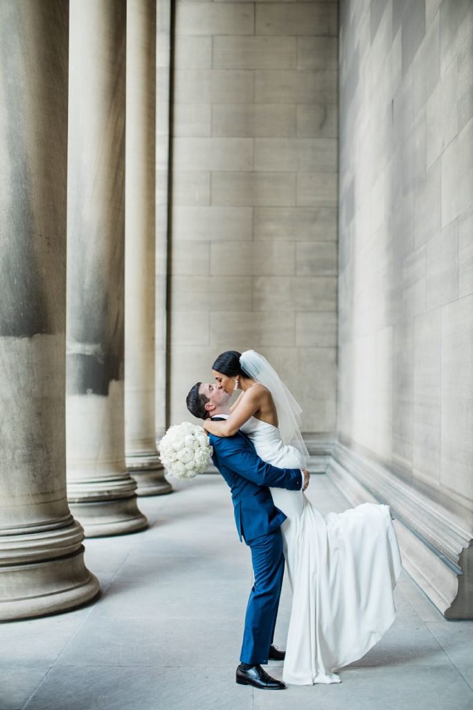 Bride and groom kiss at the Carnegie Mellon School of Engineering columns