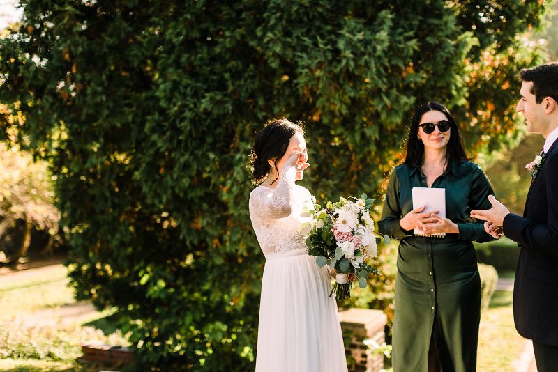 Bride wipes away a tear as groom says his vows during their fall Mellon Park elopement