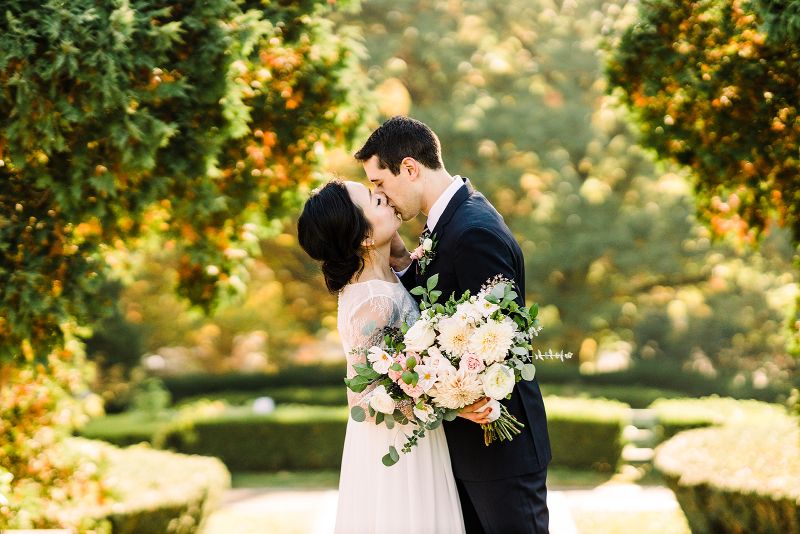 Bride and groom share their first kiss in fall Mellon Park elopement ceremony