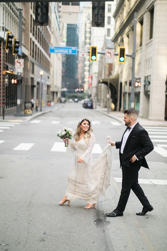 Bride and groom walk across street in Downtown Pittsburgh