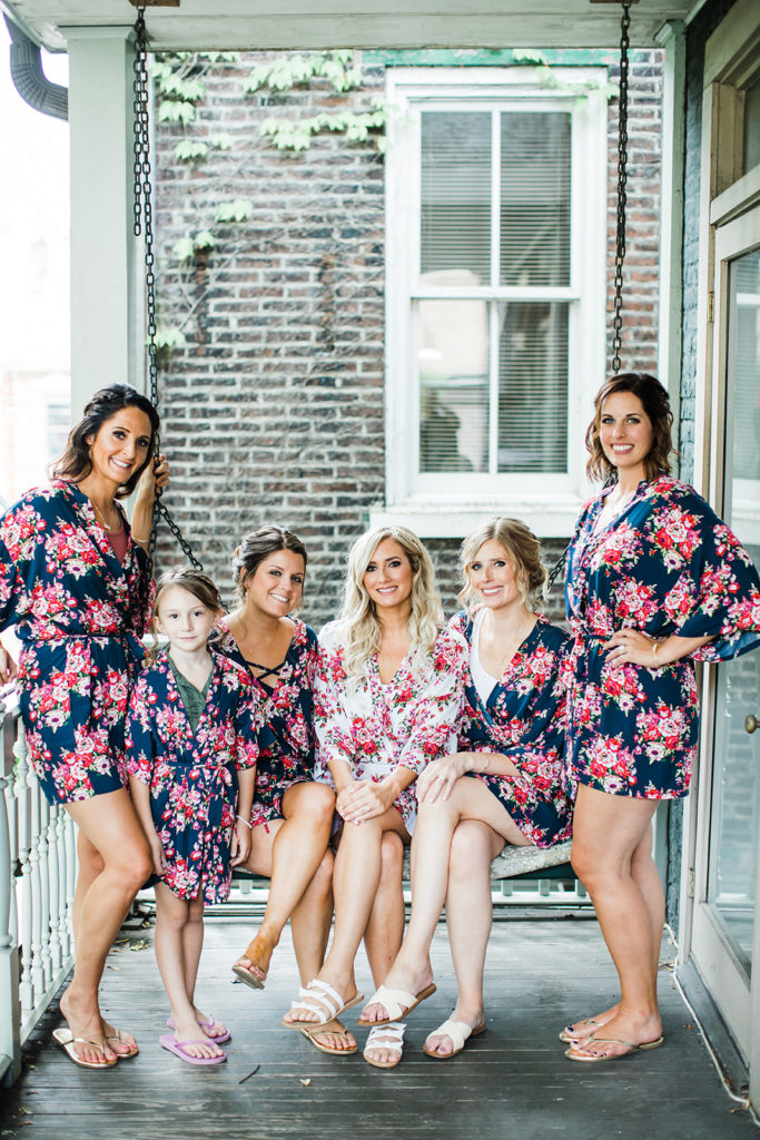 Bride and bridesmaids in floral silk robes on the balcony at the Morning Glory Inn