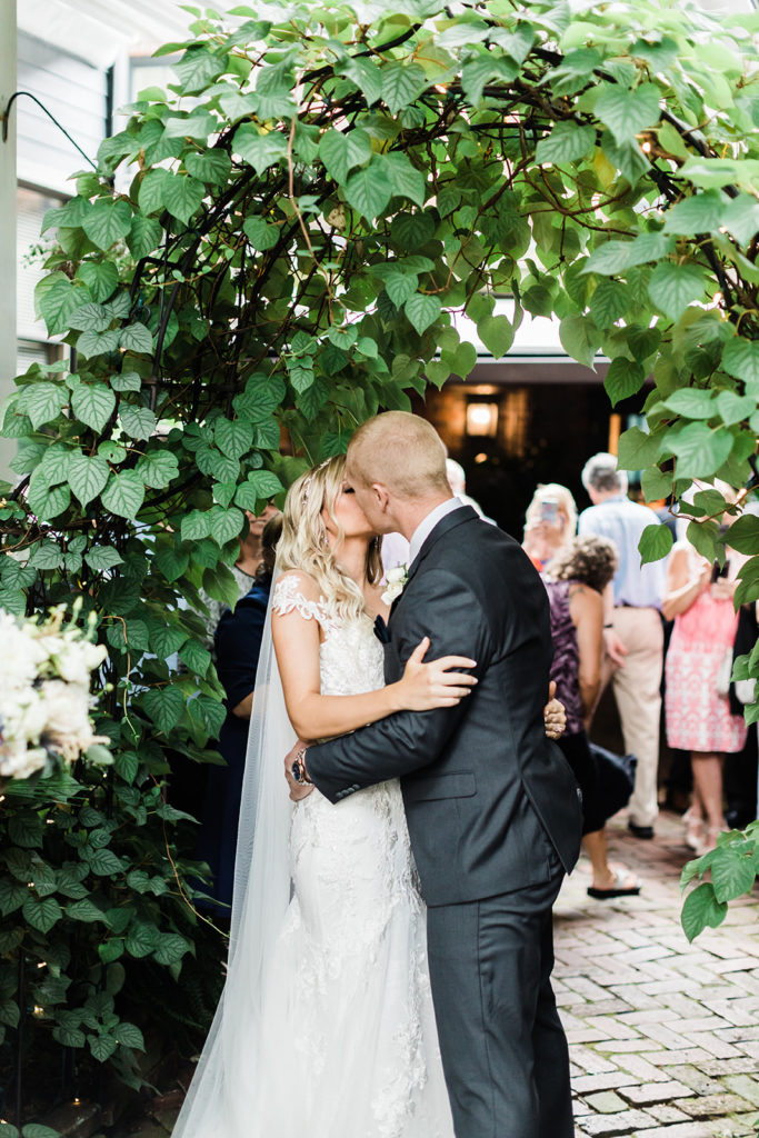 Bride and Groom kiss under the archway of the Morning Glory Inn