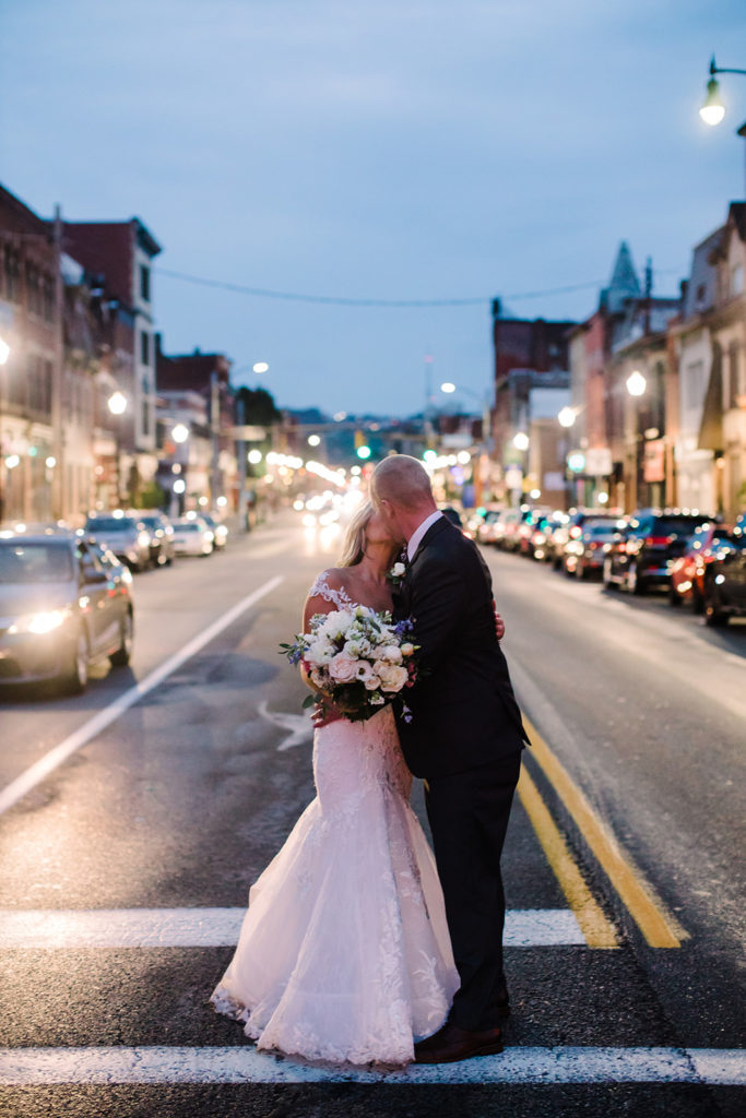 Bride and groom kiss in the middle of East Carson street