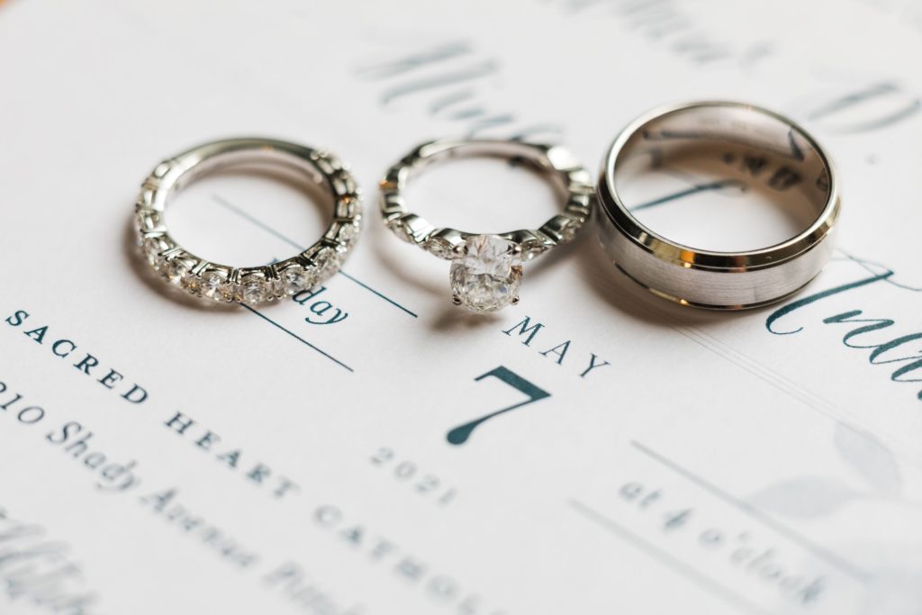 Macro photo of wedding rings sitting on a wedding invitation