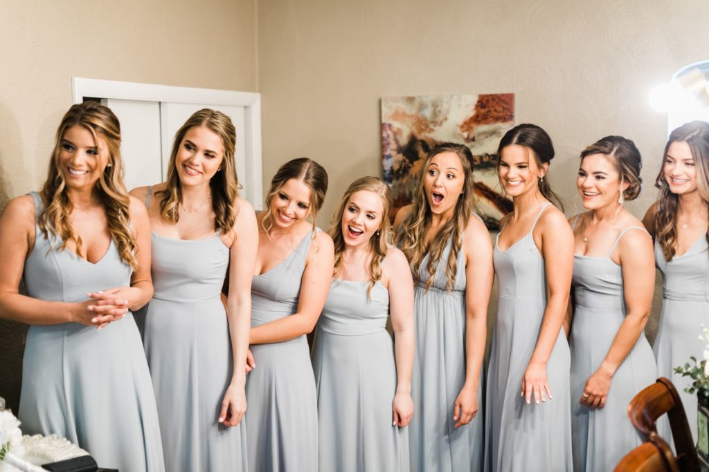 Bridesmaids react as they see the bride for the first time