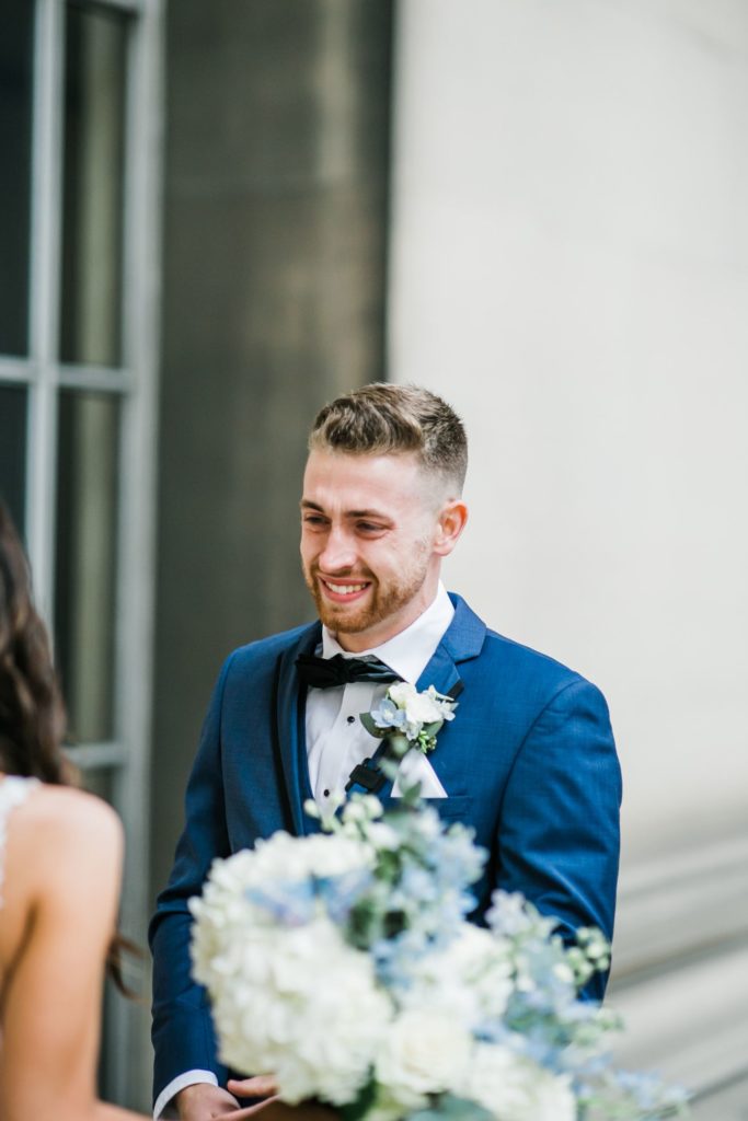 Groom smiles as he sees the bride for the first time