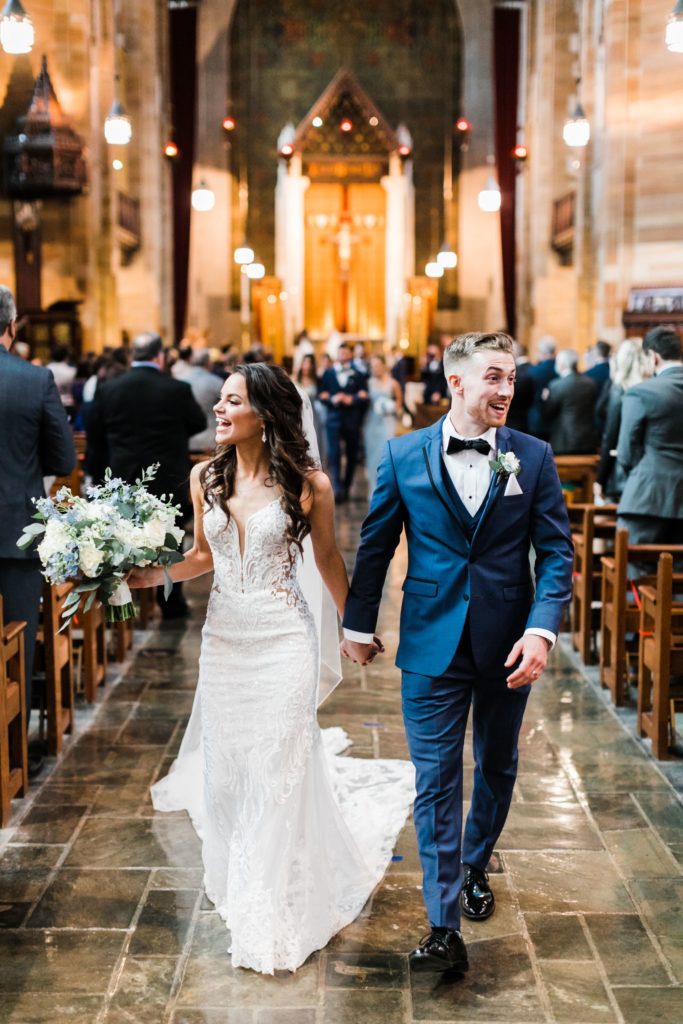 Bride and groom walk up the aisle of Sacred Heart in Shadyside