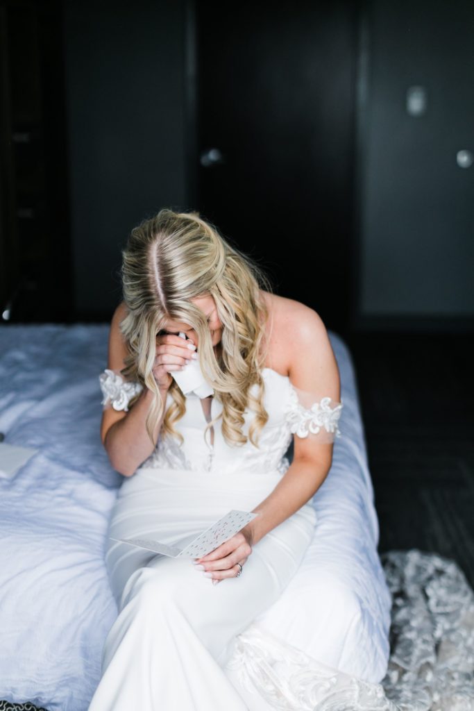 Bride cries as she reads a love note from the groom before the wedding
