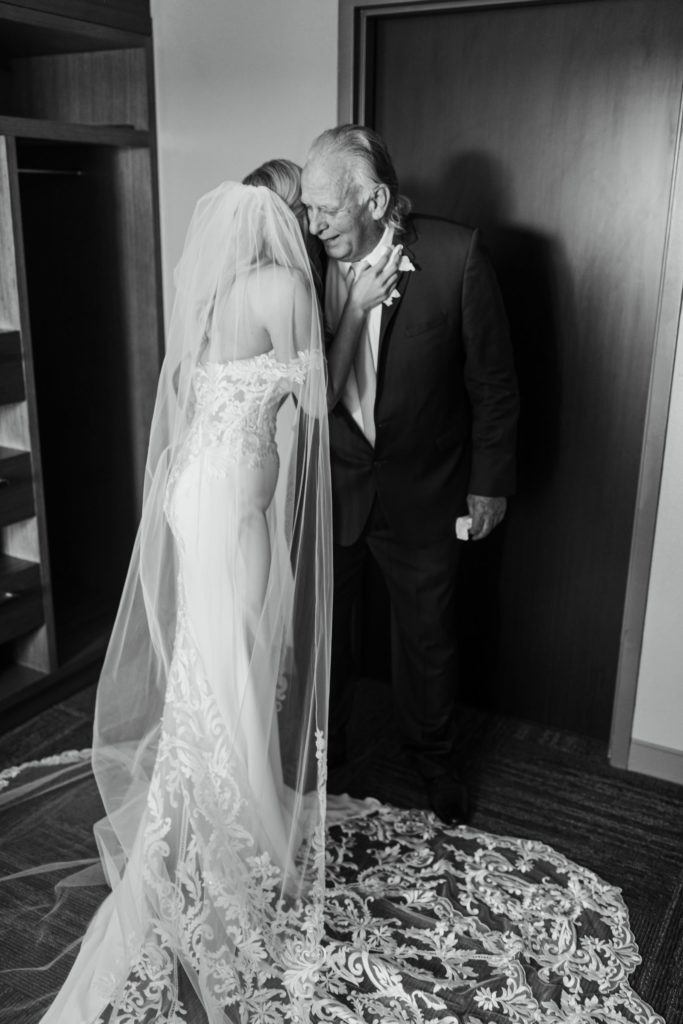 Bride embraces her father before the wedding as they both cry