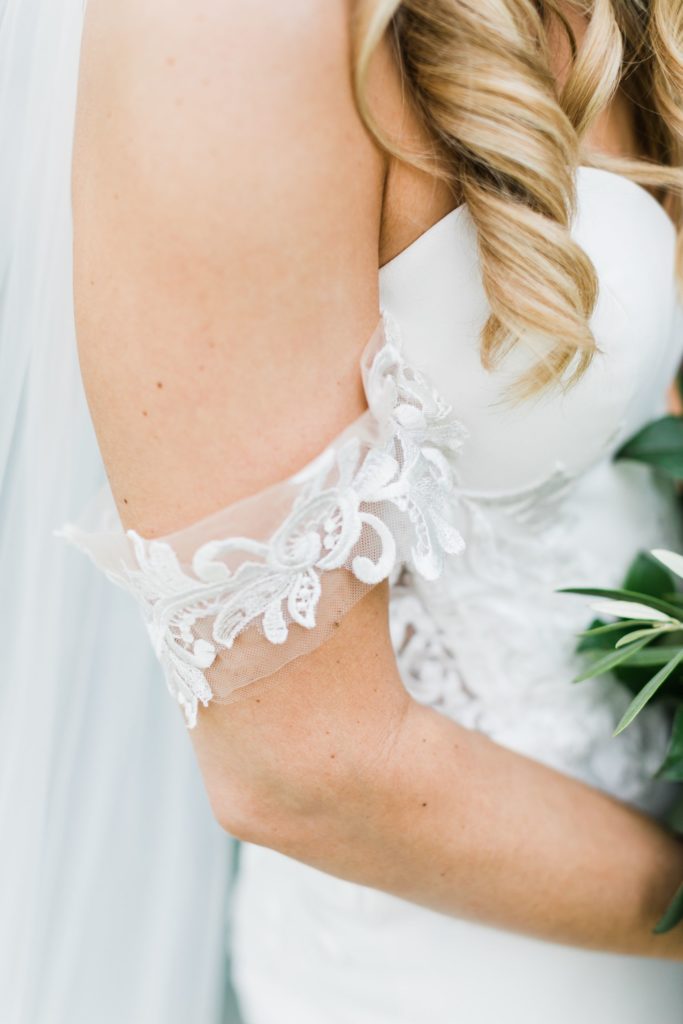 detail photo of the brides dress, showcasing her off the shoulder sleeve