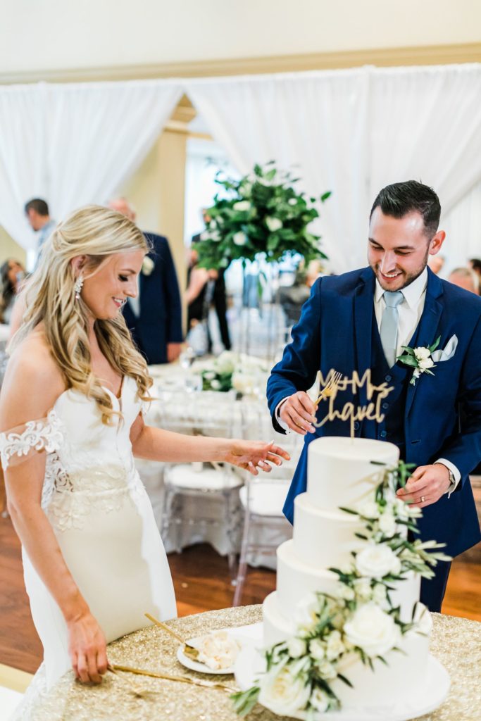 Bride and groom cut the cake at their elegant country club reception