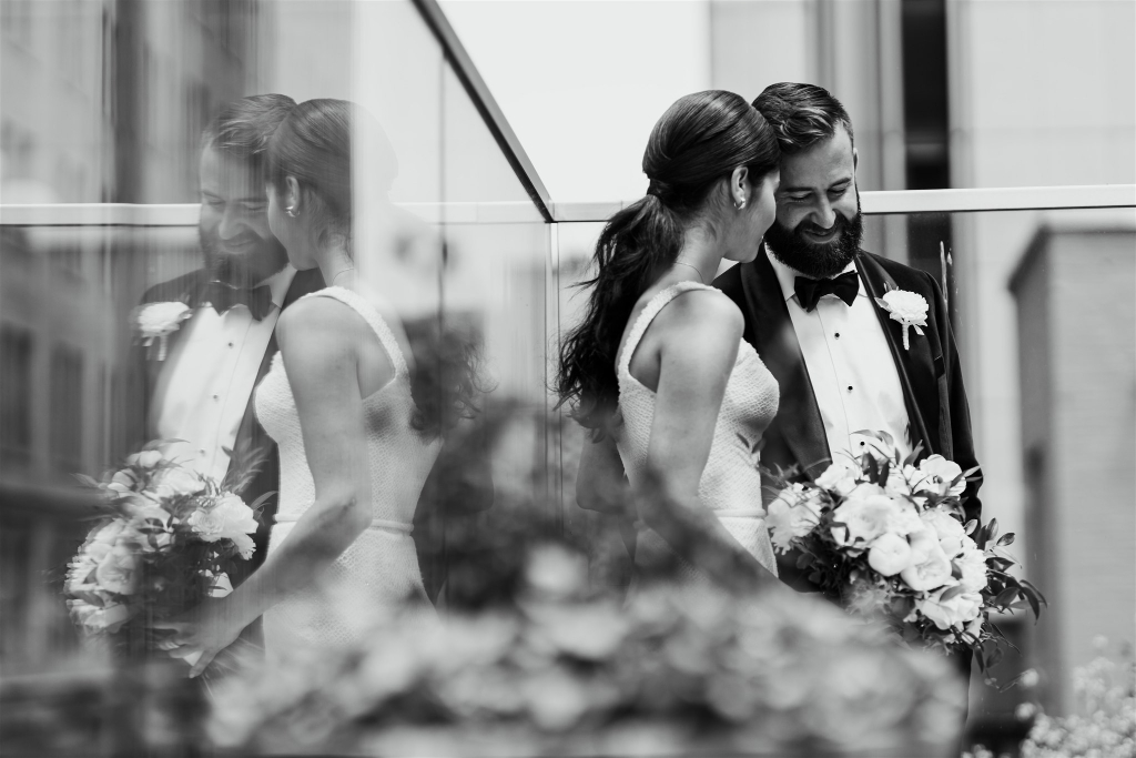 Artistic photo of bride and groom with their reflection on a wall behind them
