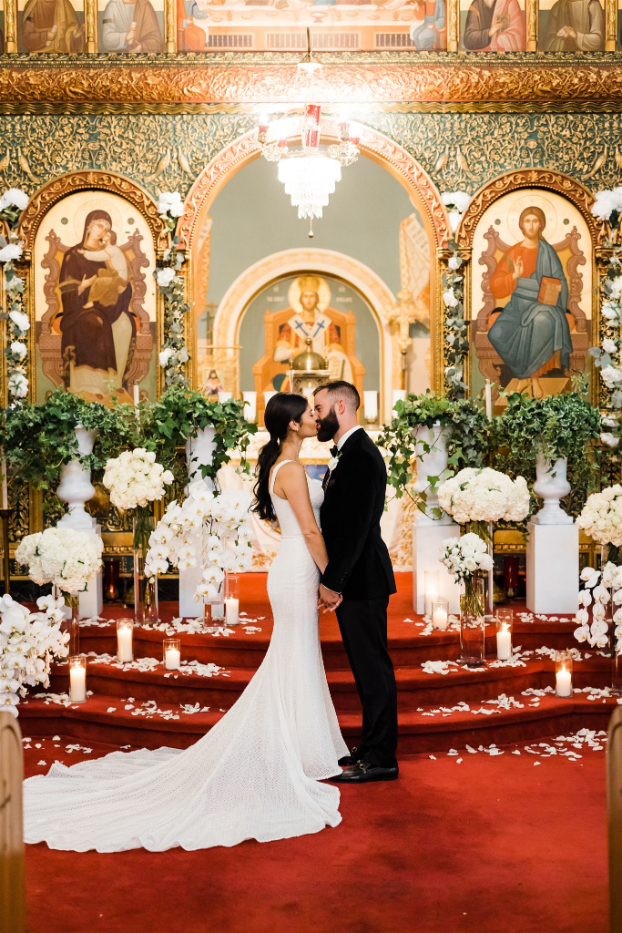 Bride and groom kiss in front of the altar