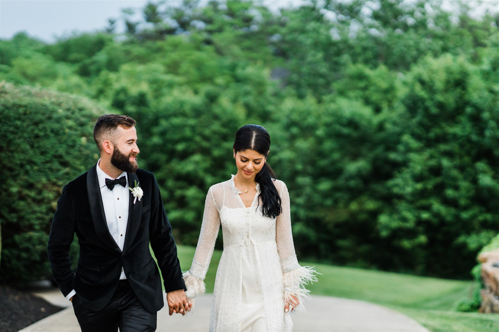 Bride and groom walk together on the property of their private Luxe Intimate Home Wedding reception