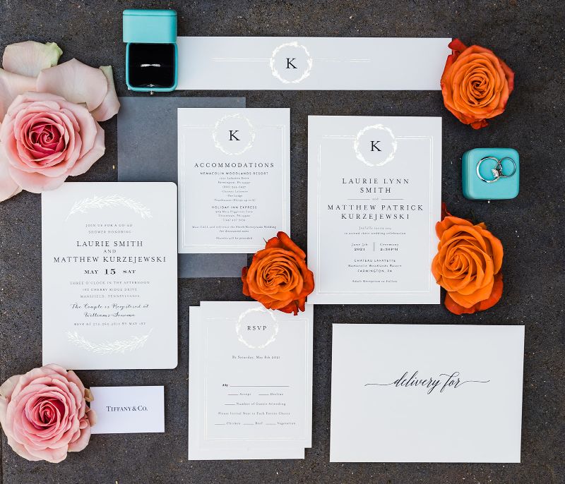 White, orange and peach flatlay of wedding stationery suite