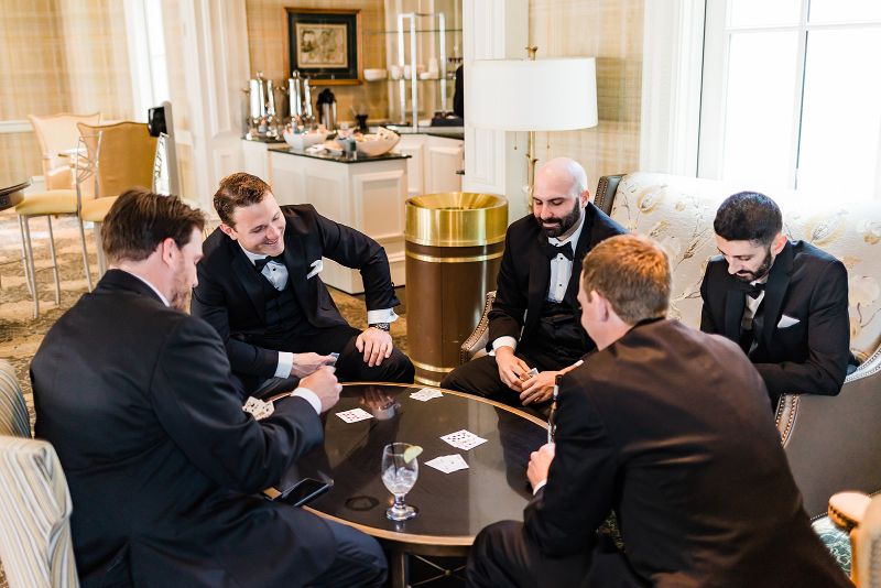 Groom plays cards with his groomsmen
