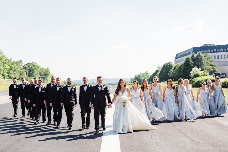 Bride and Groom walking with their bridal party on the airport runway at Nemacolin Resorts