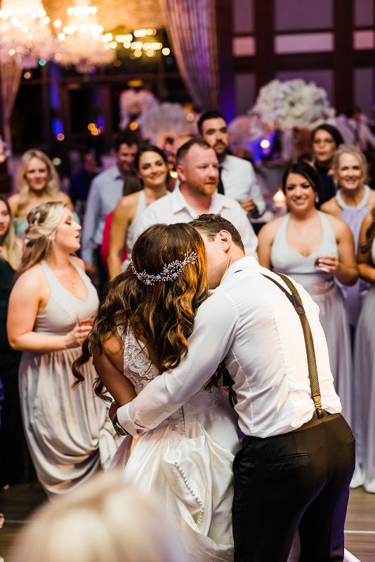 Bride and groom kiss on the dance floor at their monochromatic Nemacolin Resort wedding reception