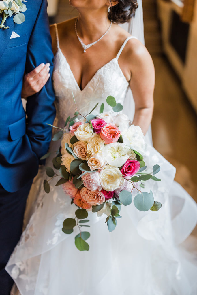 Ivory, Green, pink and peach bouquet in the hands of the bride