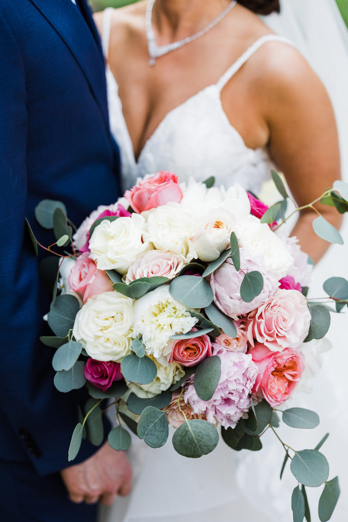 Close up photo of ivory, white, peach and pink wedding bouquet