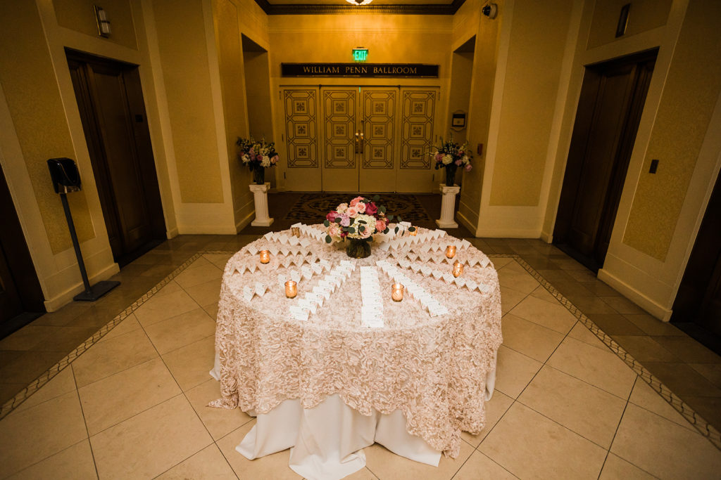 Elegant escort card table with lace overlay table cloth
