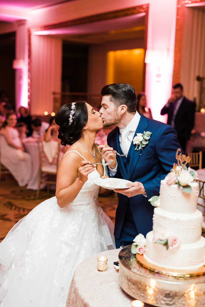 Bride and Groom kiss after cutting their cake at an Omni William Penn Wedding