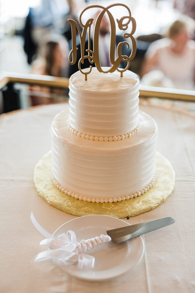 Two-tiered ivory wedding cake with monogram cake topper at Pittsburgh City view wedding reception