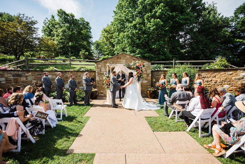 Guests look on as bride and groom get married at a vibrant Pittsburgh Botanic Garden wedding