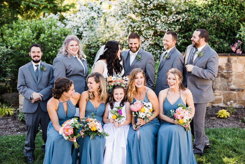 A happy bridal party smiles as they take portraits together