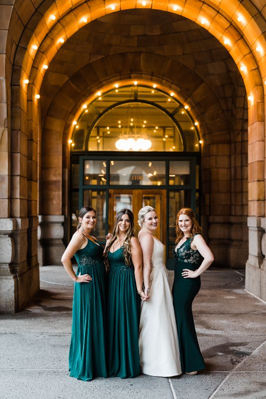 Bride and bridesmaids pose in front of the Pennsylvanian
