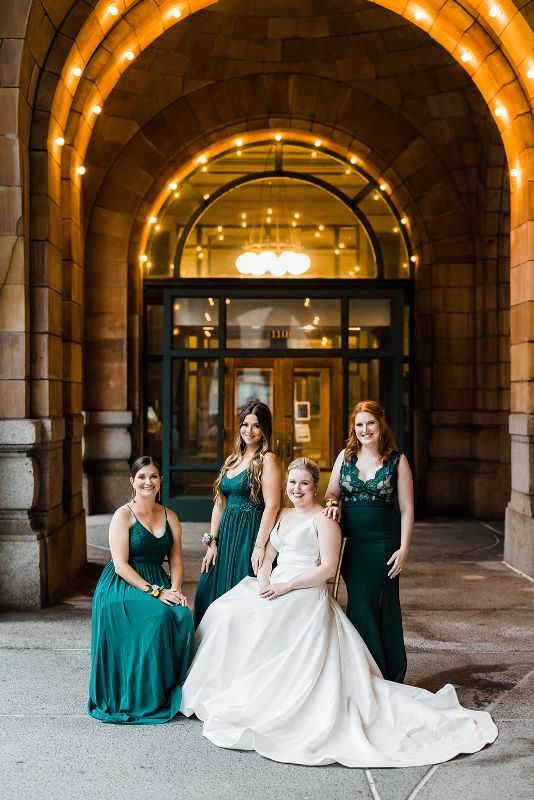 Bride and bridesmaids pose in front of the Pennsylvanian
