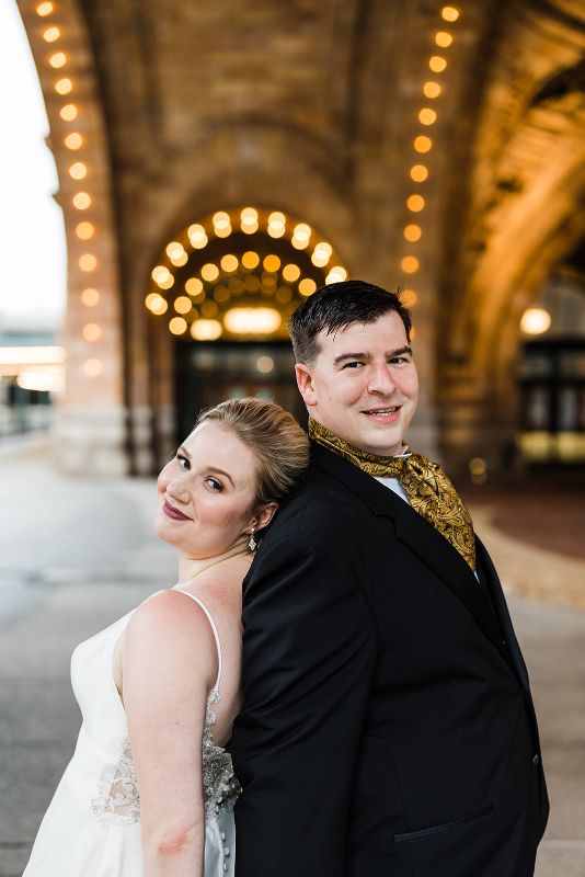 Bride and groom pose together in front of the Pennsylvanian at their downtown Pittsburgh vow renewal
