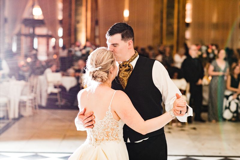 Bride and groom share first dance at downtown Pittsburgh vow renewal and groom kisses her forehead