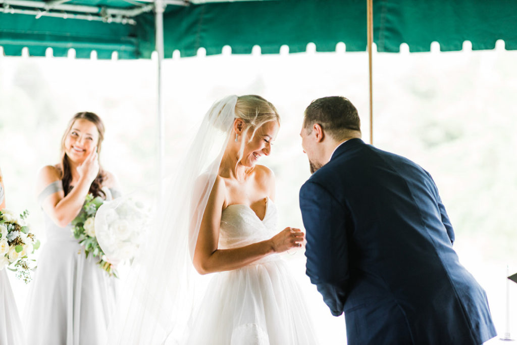 Bride and groom laugh together during Oakmont Country Club wedding outdoor ceremony