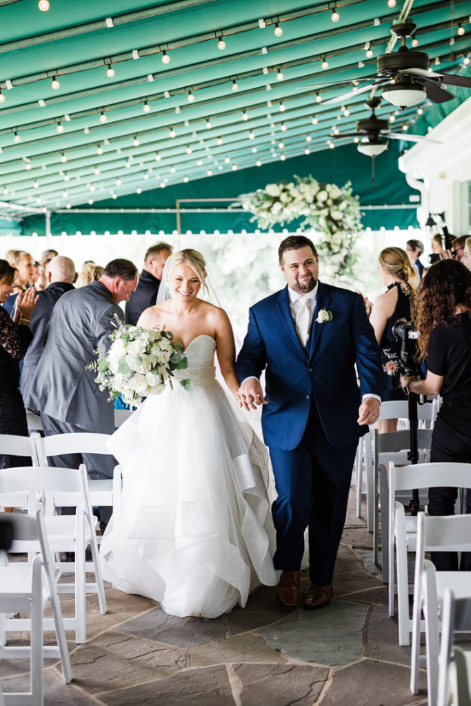 Bride and groom walk up the aisle at their Oakmont Country Club wedding