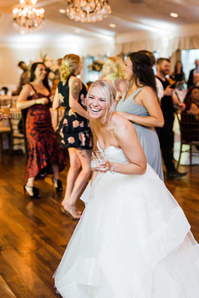 Bride laughs on the dance floor of the Oakmont Country Club