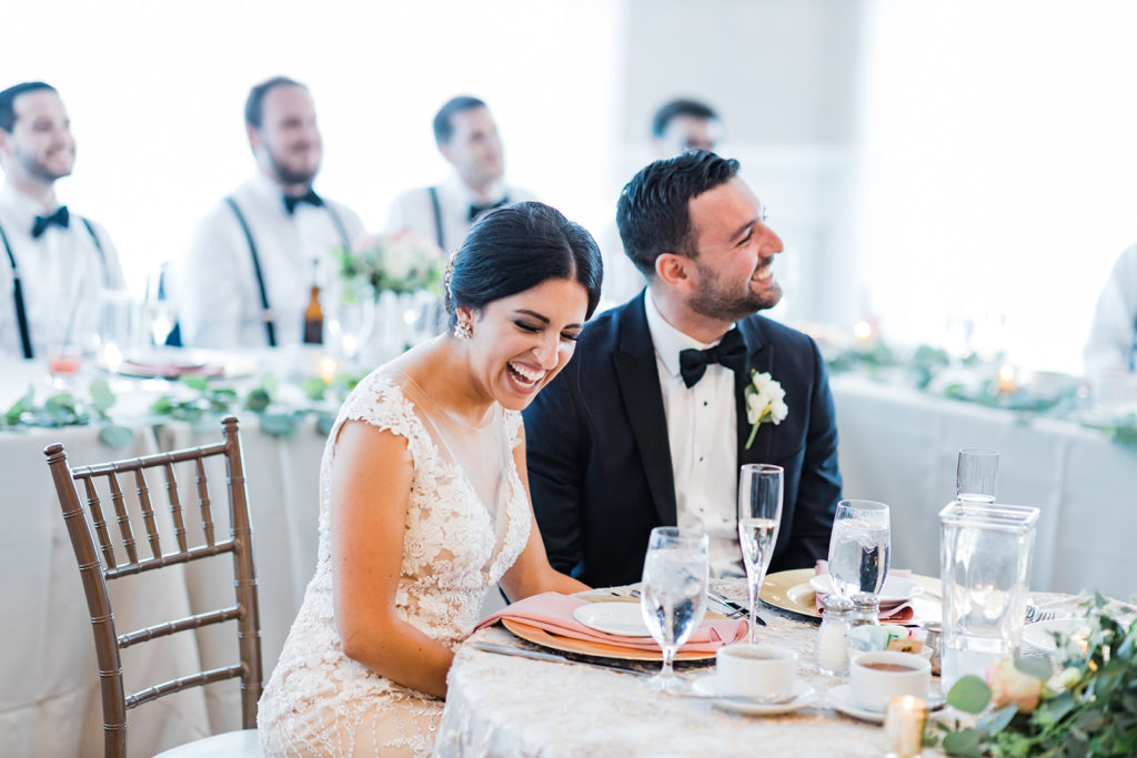 Bride and groom laugh during speeches