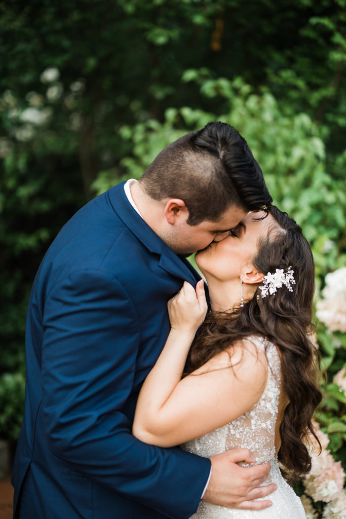Bride and groom hold each other and kiss outside