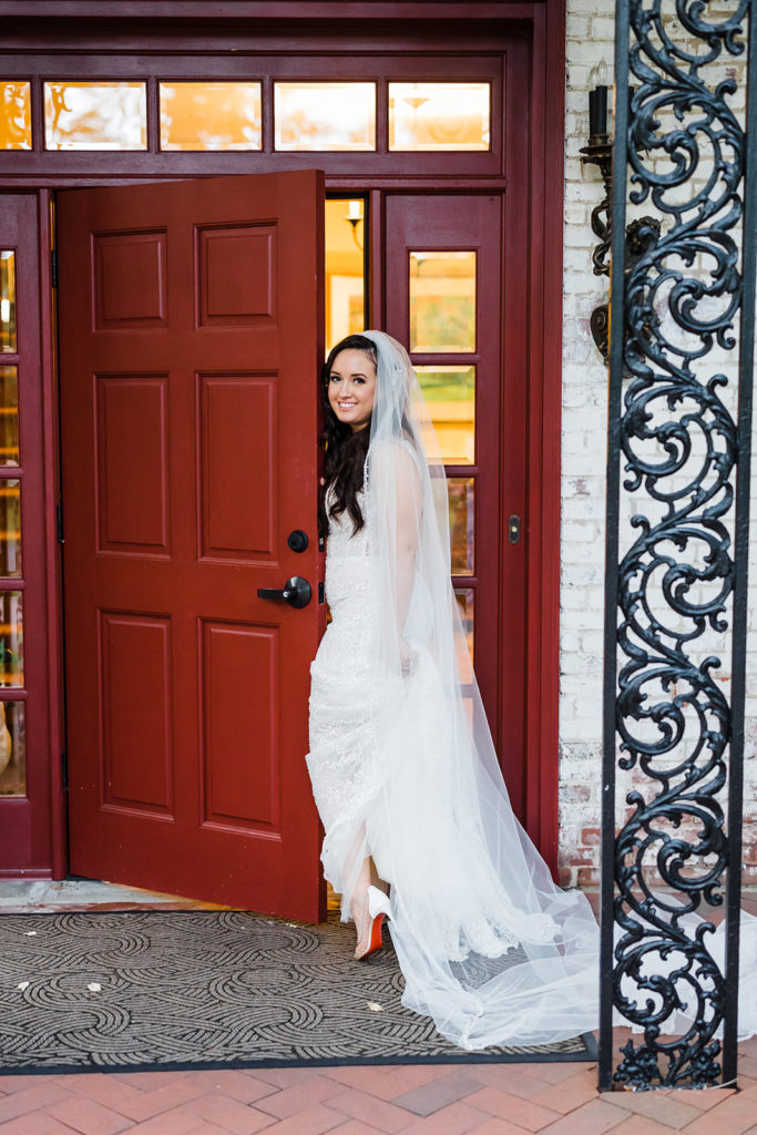 Bride stands near a red door at Succop Nature Park Wedding