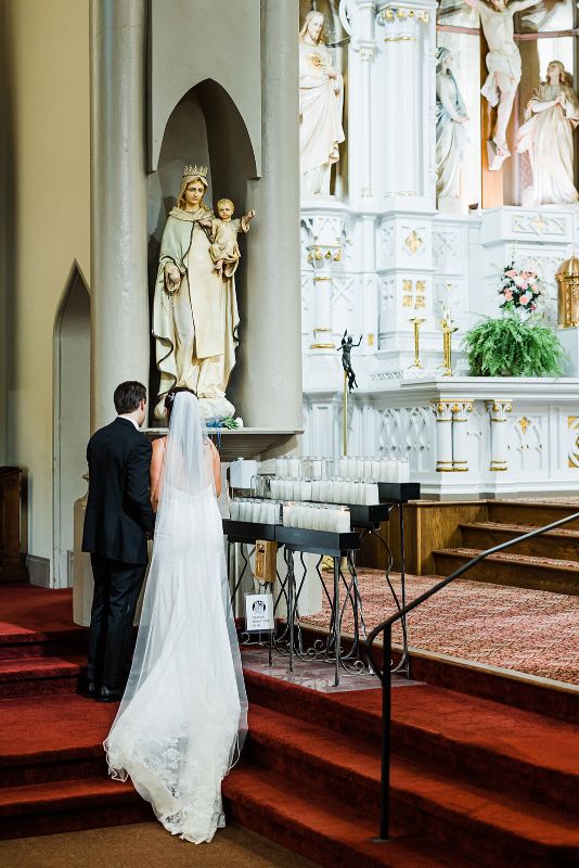 Bride and groom pay their respects to Mary during their wedding ceremony